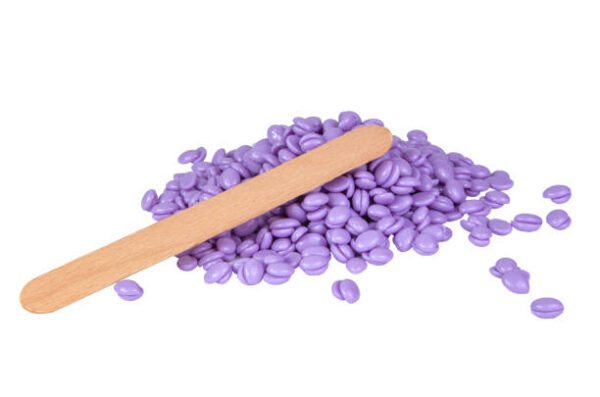 Aromatherapy violet lavender wax drops for depilation isolated on the white